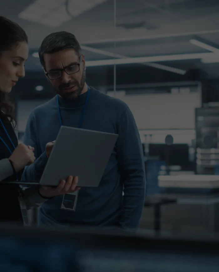Two engineers working together on a laptop